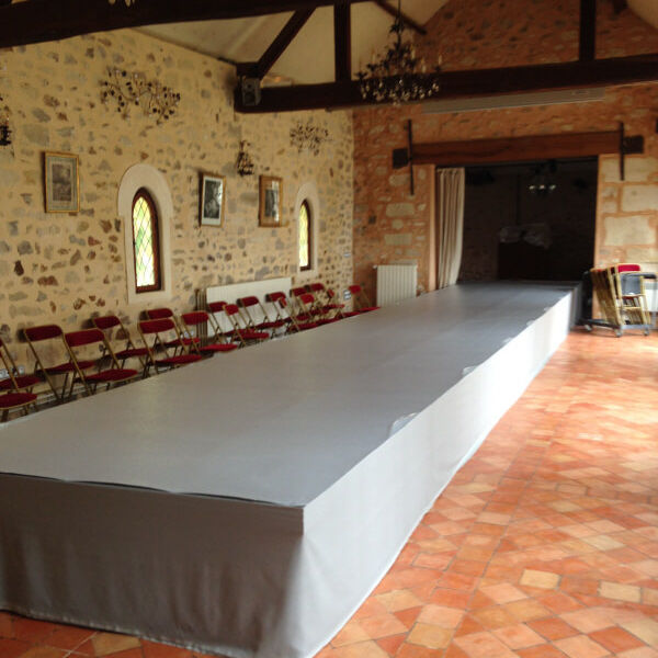 INSTALLATION ESTRADE AVEC MOQUETTE GRISE ET JUPAGE GRIS POUR DEFILE DE MODE